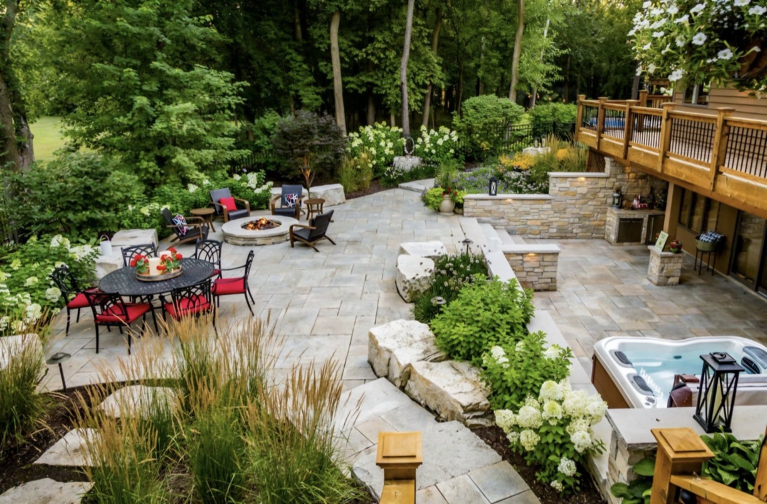 Completed outdoor living patio with seating, fire pit, planting and stone pavers